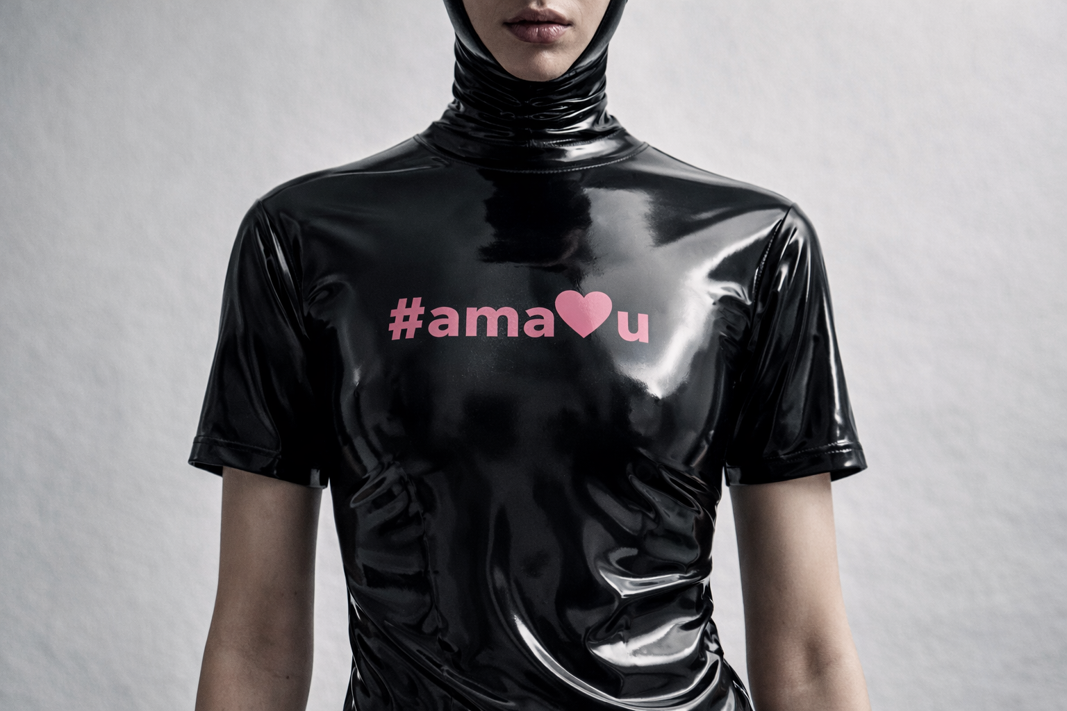 Person wearing a black shiny outfit with '#ama❤️❤️' text on a gray background